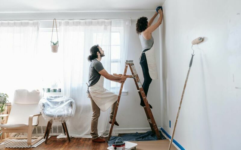 Mann und Frau streichen einen Raum