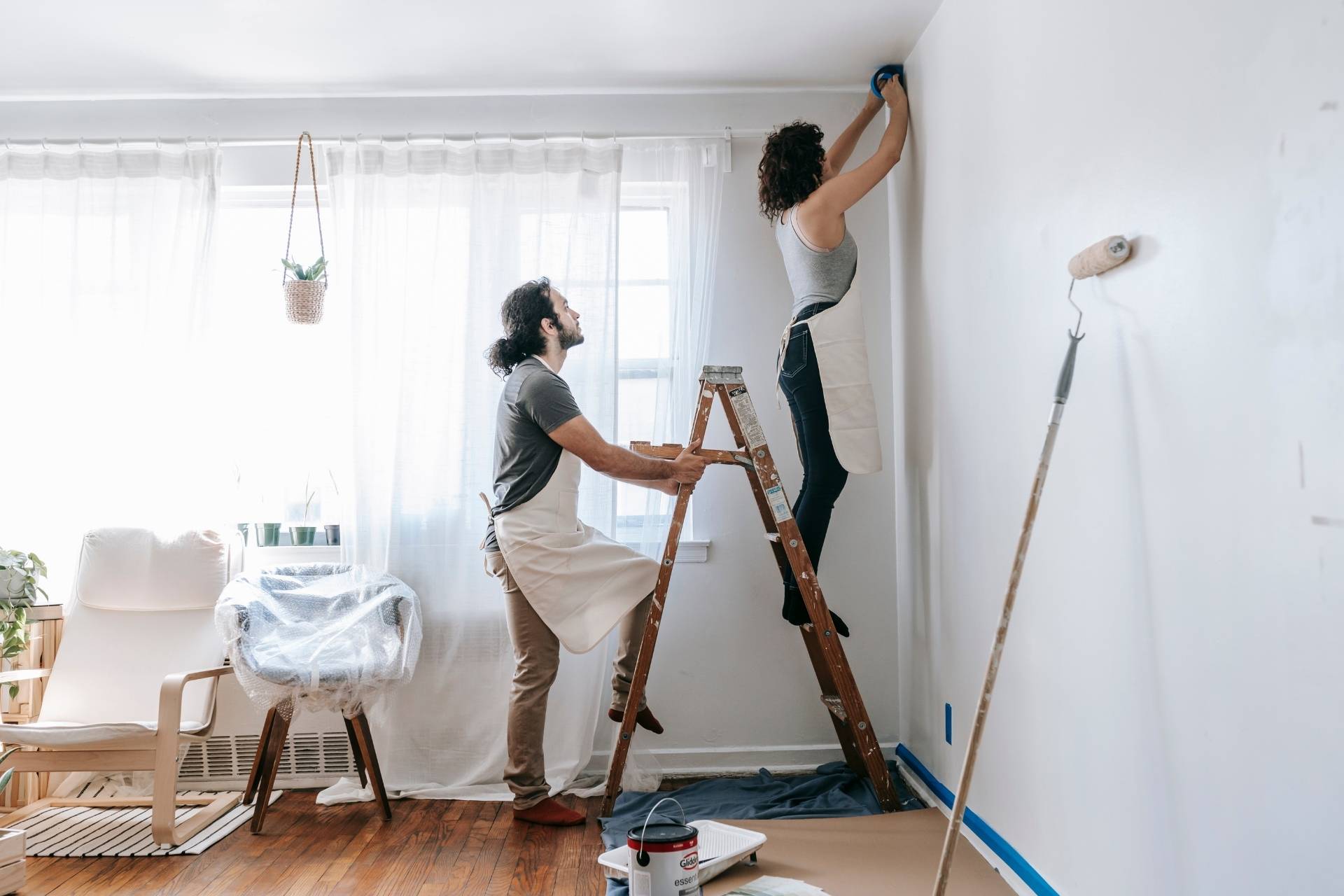 Mann und Frau streichen einen Raum